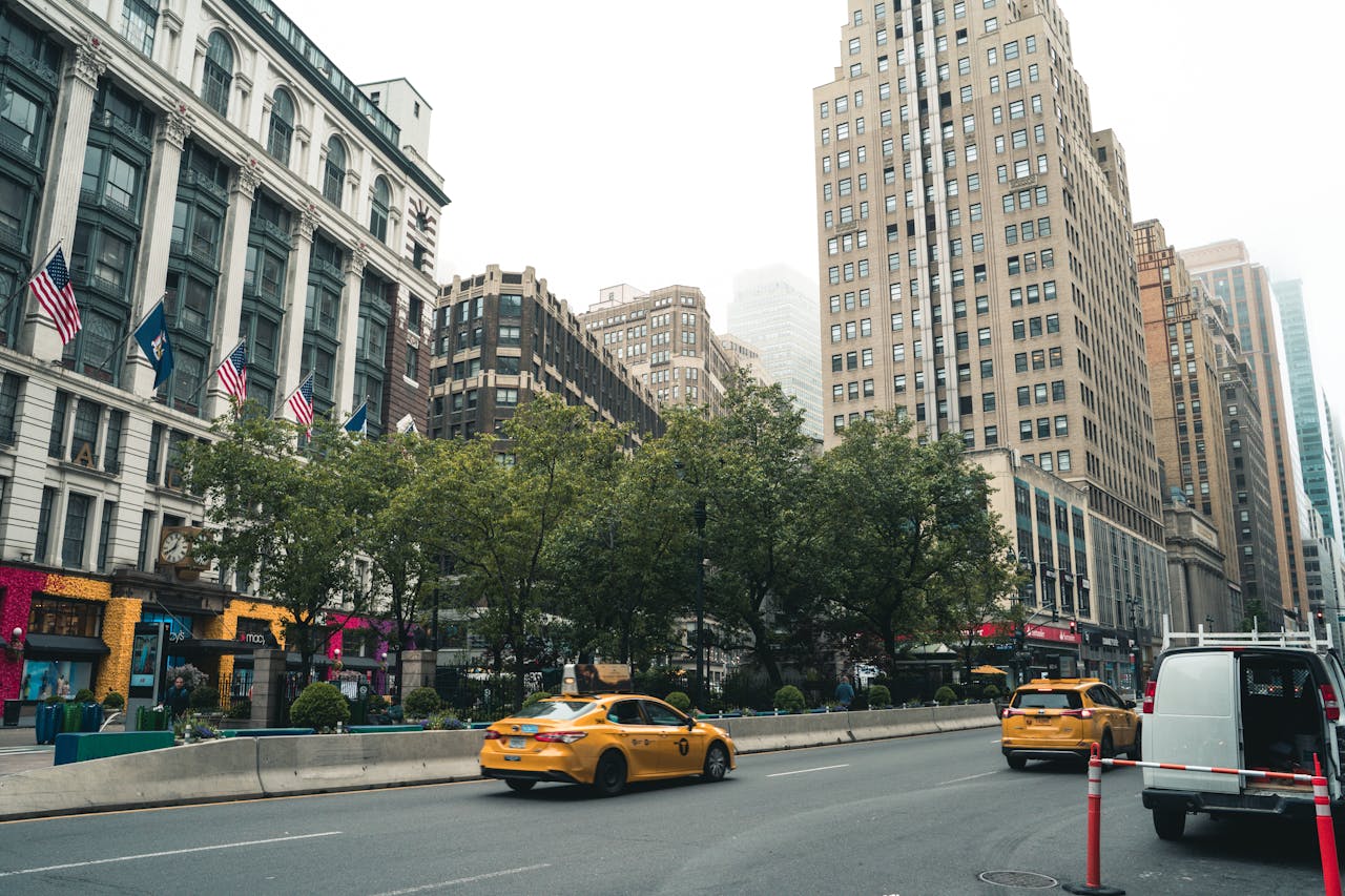 services-03 Urban scene showcasing busy New York City street with yellow taxis, towering skyscrapers, and vibrant storefronts.